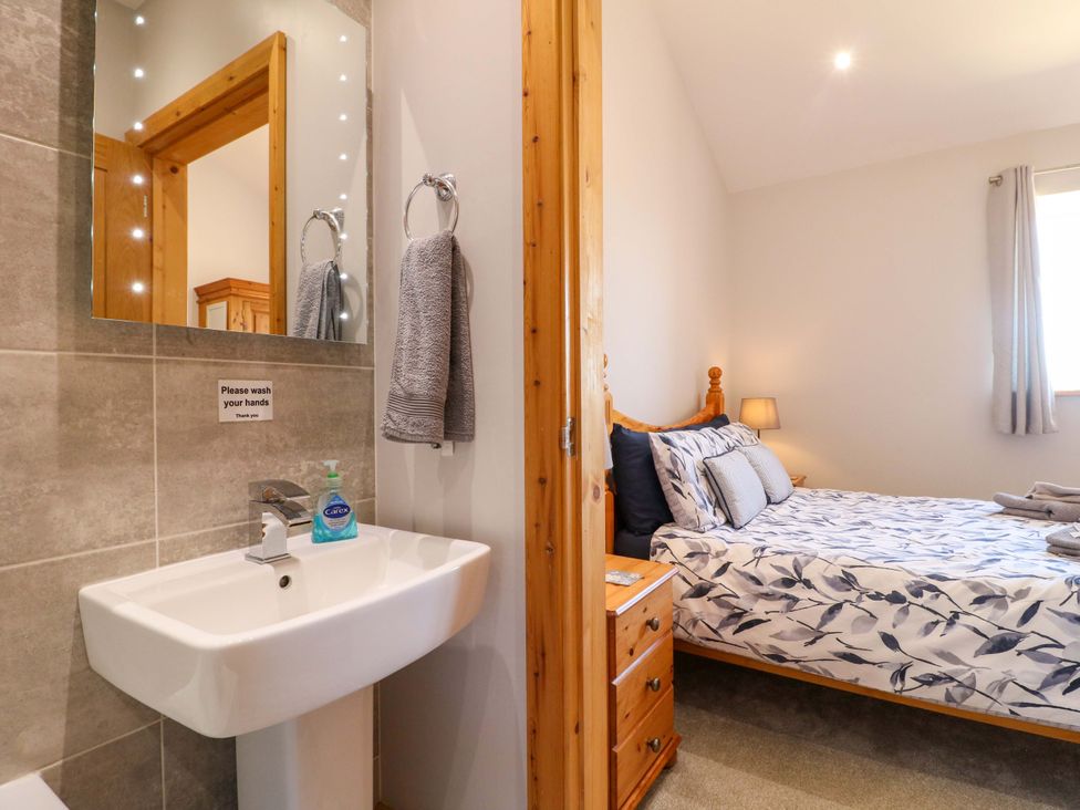 A bedroom with a bed and sink at Teal Cottage in Melton Mowbray