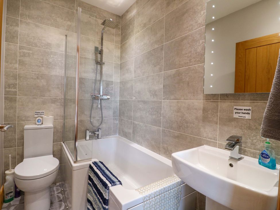 A bathroom featuring a bathtub, toilet, sink, and shower at Teal Cottage in Melton Mowbray