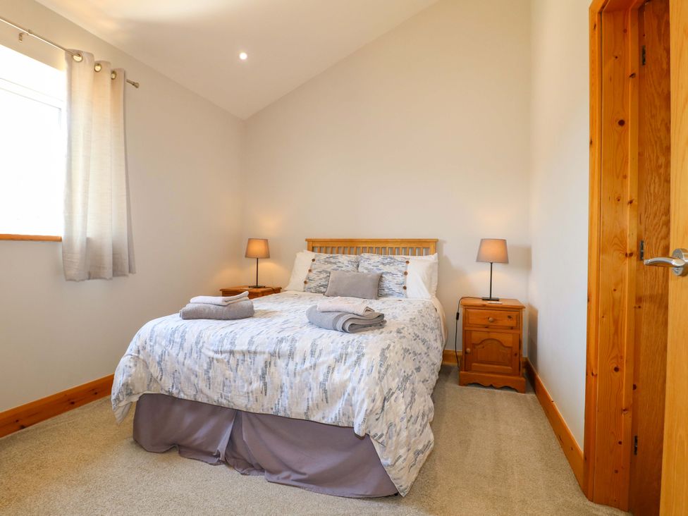 A bedroom with a bed and nightstand at Teal Cottage in Melton Mowbray
