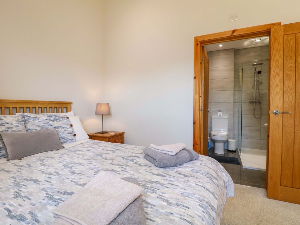 A bedroom with a bed and an attached bathroom at Teal Cottage in Melton Mowbray
