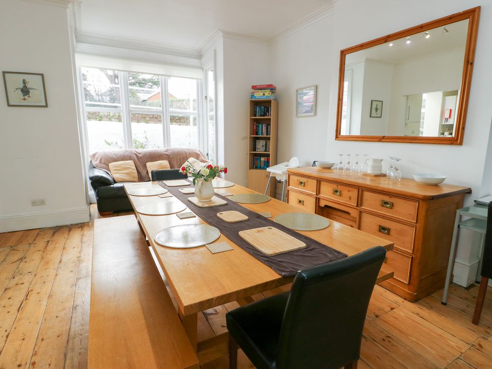 A dining room with a large table and sofa at Preswylfa in Caernarfon