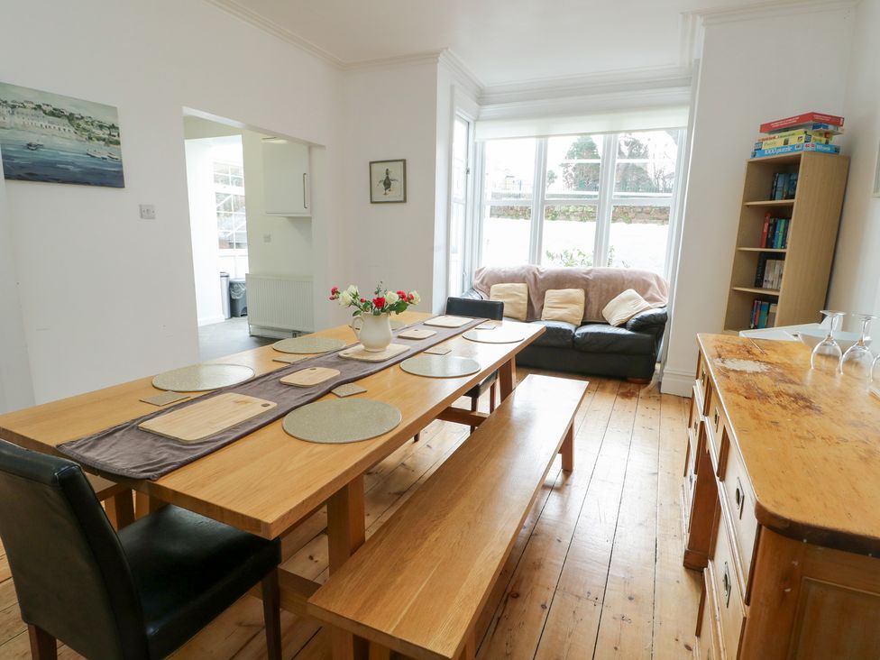 A dining room with a table and sofa at Preswylfa in Caernarfon