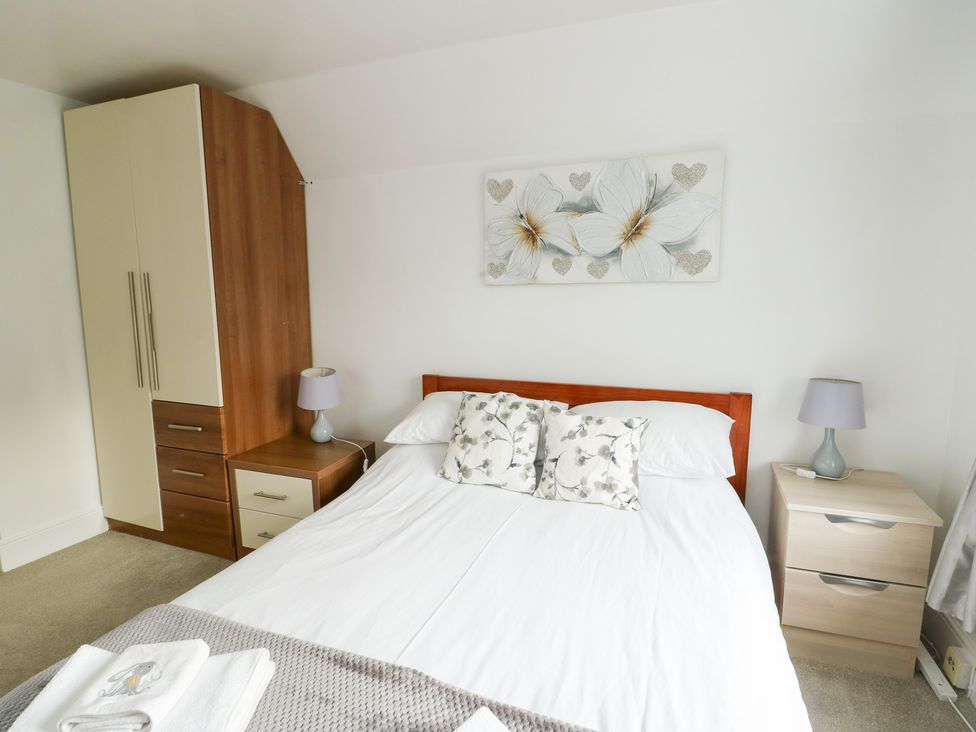 A bedroom with a bed and wardrobe at Preswylfa, Caernarfon