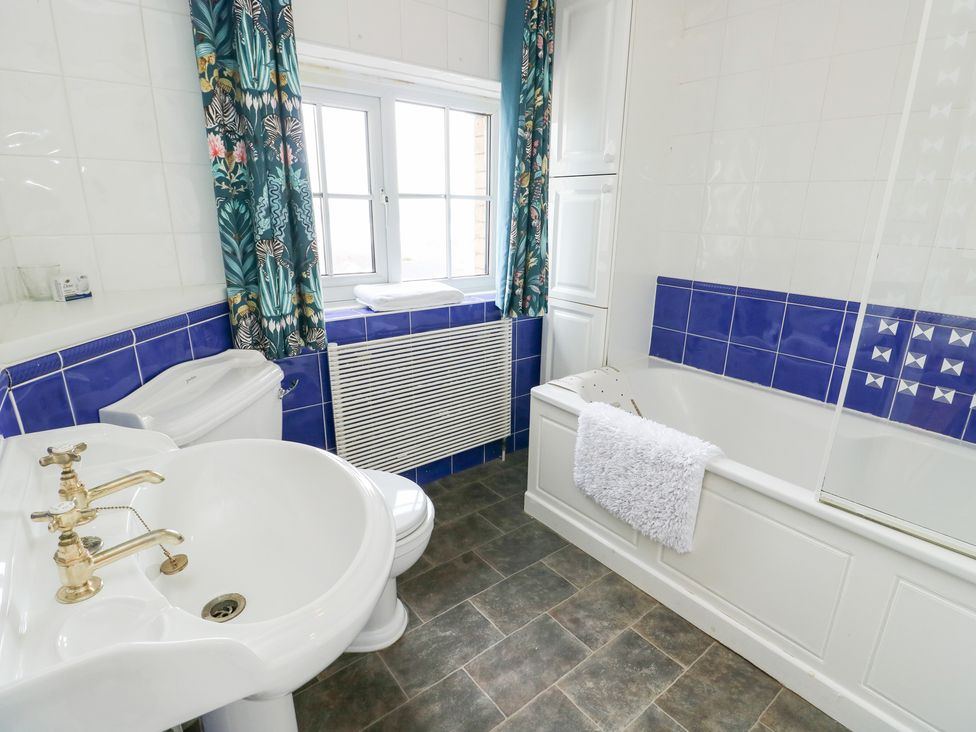 A bathroom with a bath tub, toilet, and sink at Preswylfa in Caernarfon