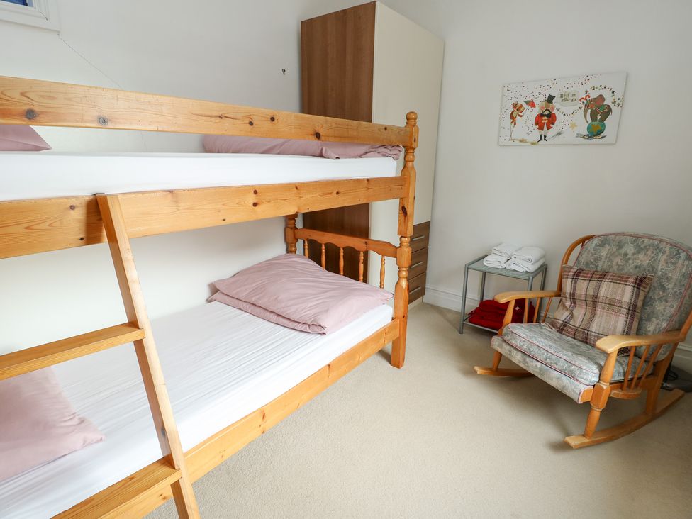 A bedroom with a bunk bed and a rocking chair at Preswylfa, Caernarfon