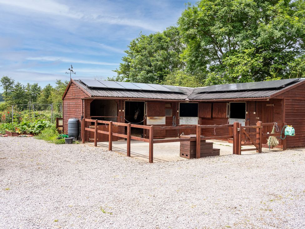 A stable with fencing and a water barrel at Willow Barn in Cucklington near Wincanton