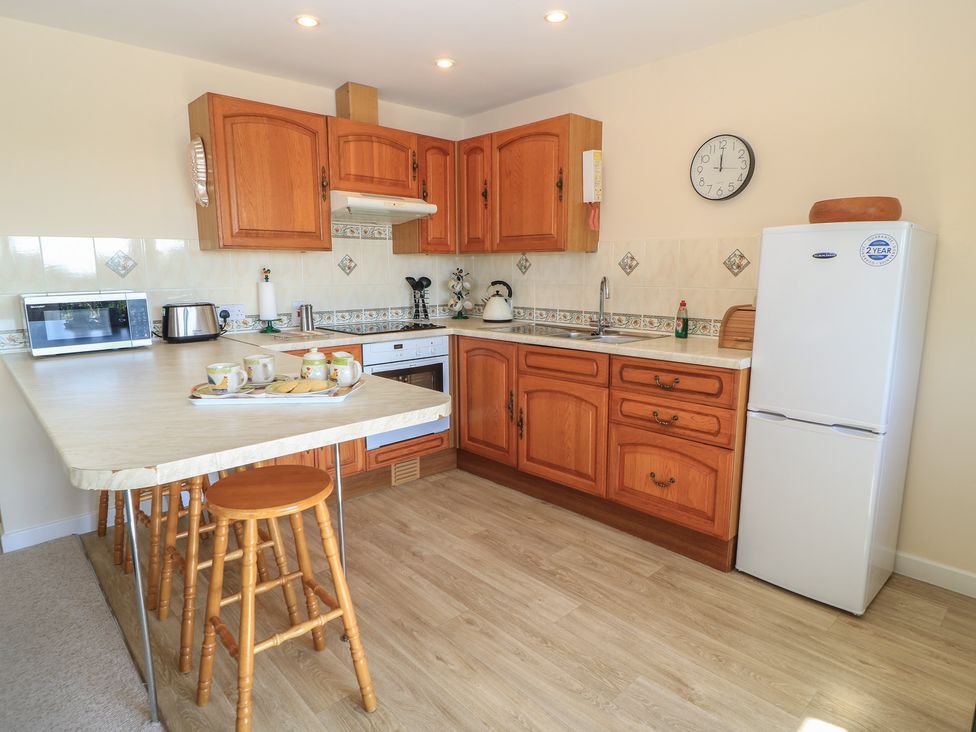 A kitchen with wooden cabinets and appliances at Willow Barn Cucklington near Wincanton