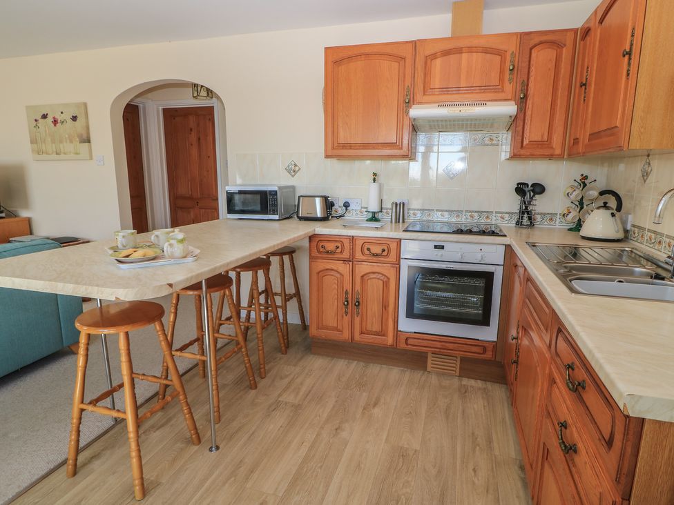 A kitchen with appliances and a dining area at Willow Barn Cucklington near Wincanton