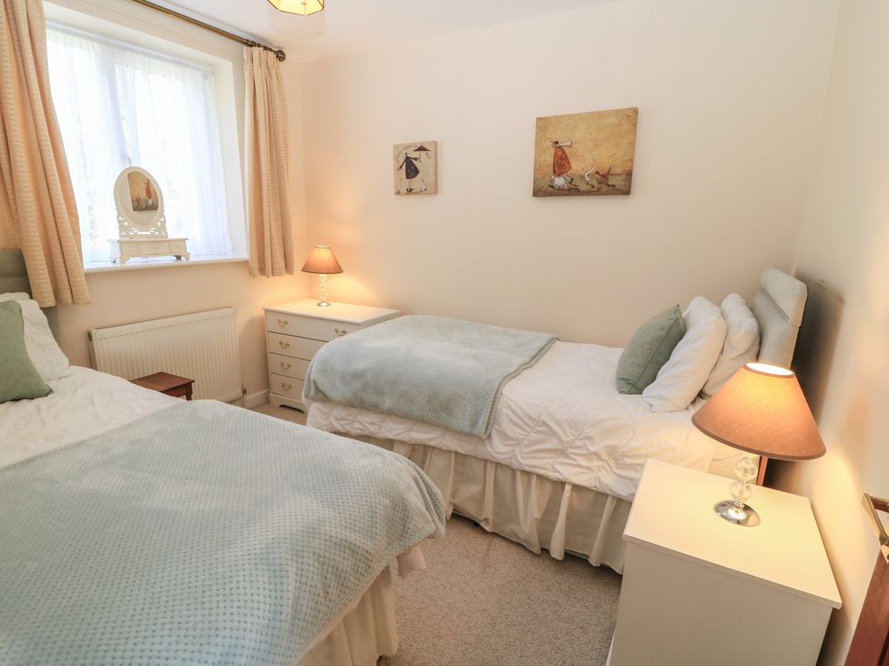A bedroom with two beds and a nightstand at Willow Barn in Cucklington near Wincanton
