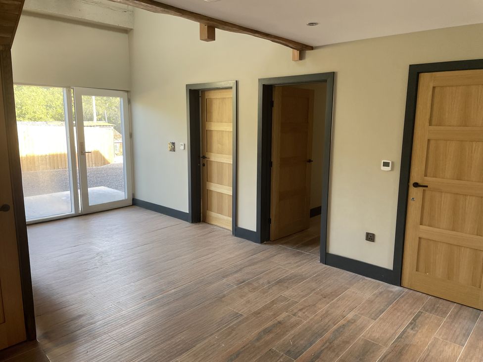 An indoor space with doors and sliding doors at 1 New Dairy Barn