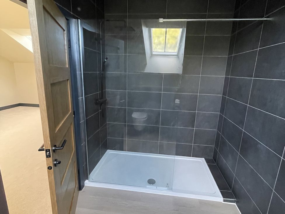 A shower area with a glass partition and door at 1 New Dairy Barn 