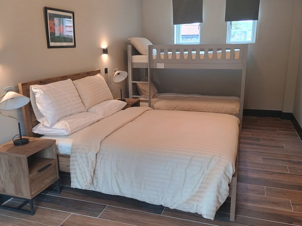 A bedroom with a double bed and a bunk bed at 1 New Dairy Barn Croxdale