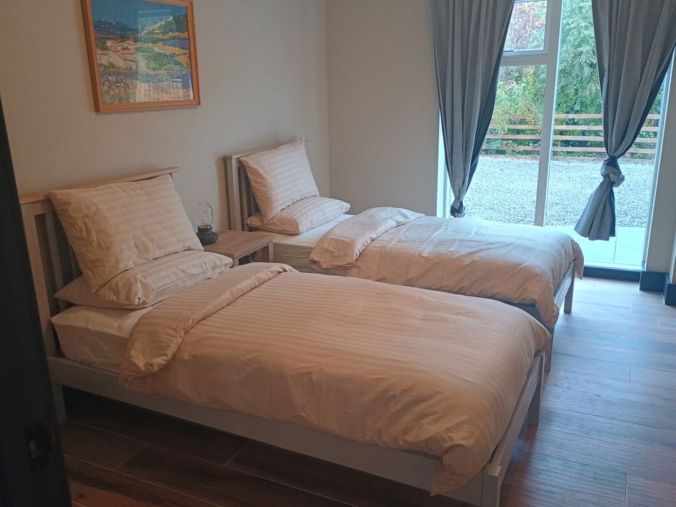A bedroom with two beds and a window at 1 New Dairy Barn Croxdale