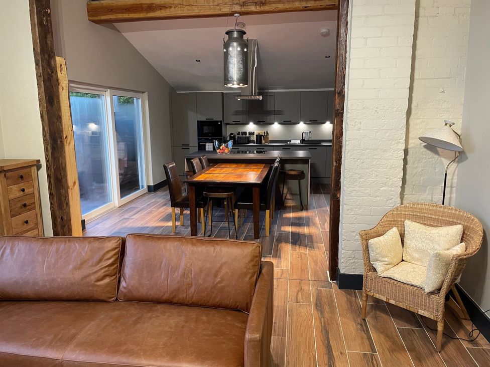 A living room with a sofa and dining area at 1 New Dairy Barn in Croxdale