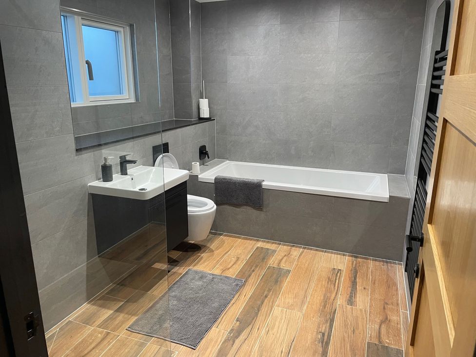 A bathroom with bathtub, sink and toilet at 1 New Dairy Barn in Croxdale
