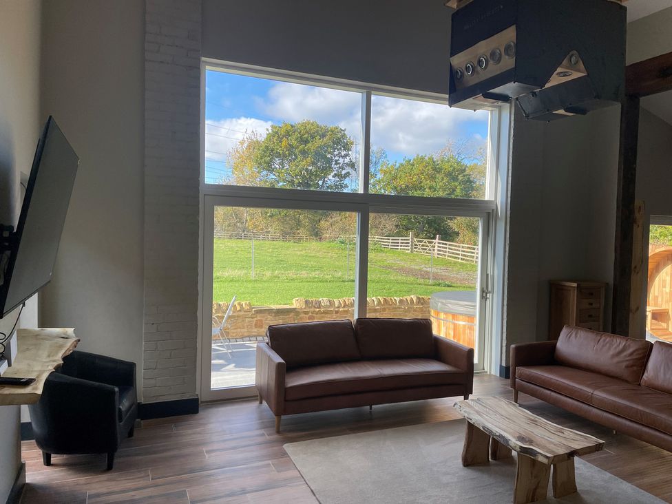 A living room with a sofa and television at 1 New Dairy Barn in Croxdale