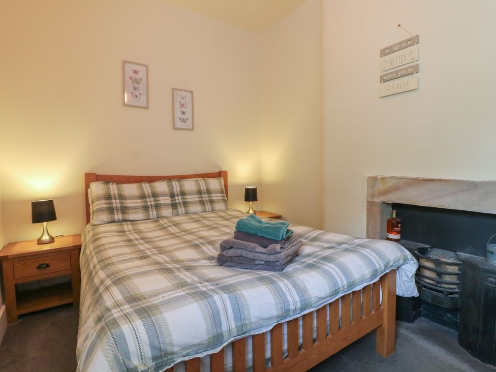 A bedroom with a bed and nightstand at Milford Cottage in Milford near Duffield