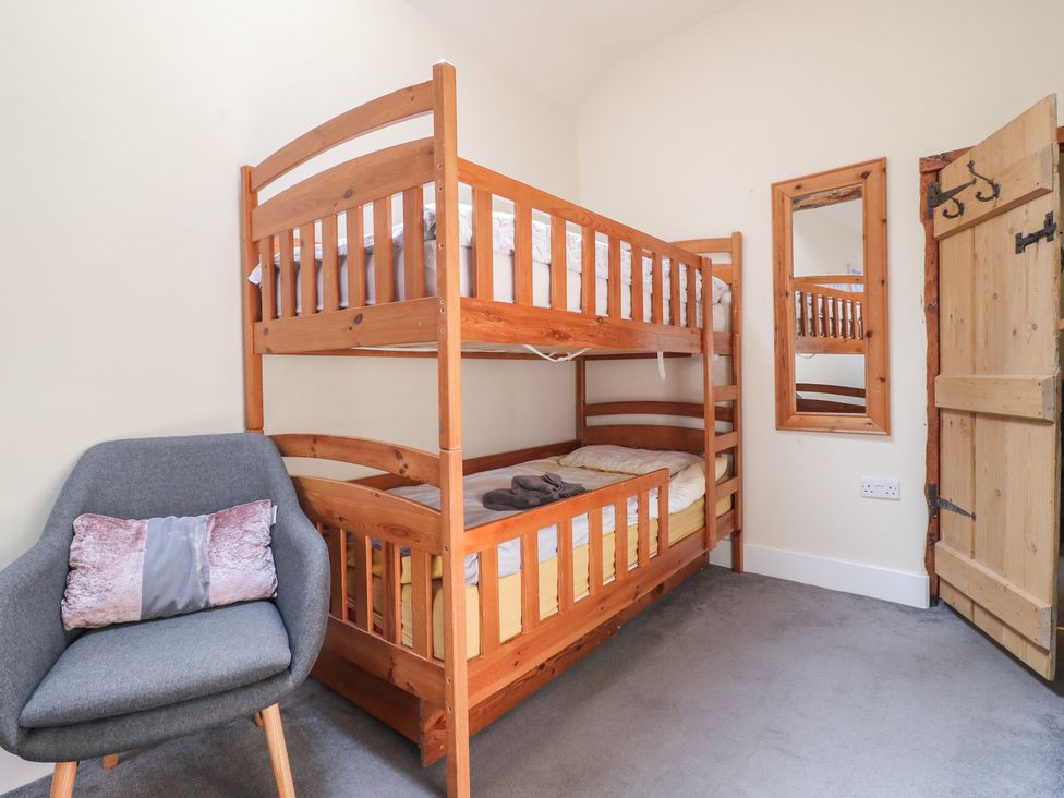A bedroom with a bunk bed and a chair at Milford Cottage in Milford near Duffield