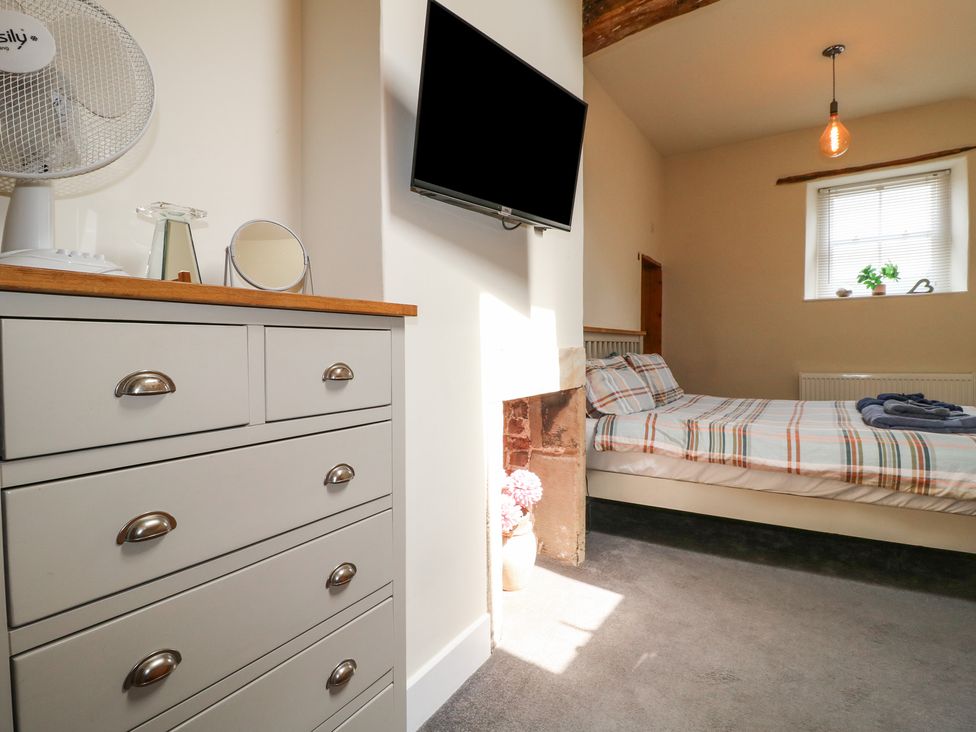 A bedroom with a bed and television at Milford Cottage in Milford near Duffield
