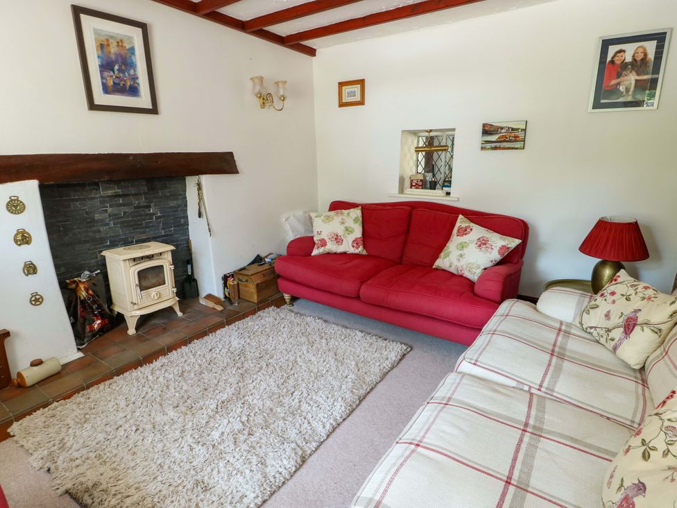 A living room with a red sofa and fireplace at Bryn Pydew in Llandudno Junction