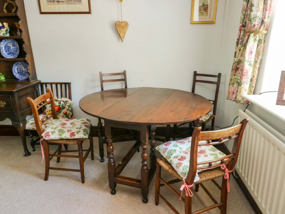A dining room with a round table and chairs at Bryn Pydew in Llandudno Junction