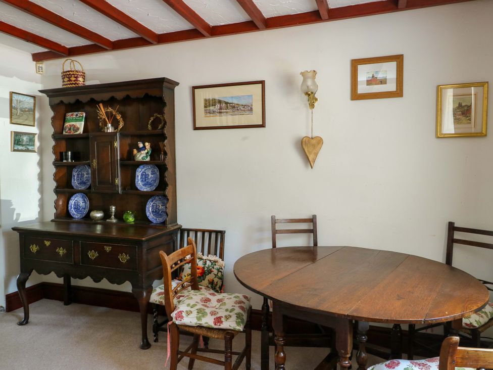 A dining room with a table and chairs at Bryn Pydew in Llandudno Junction