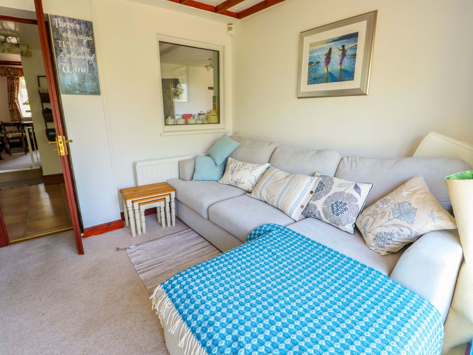 A living room with a sofa and side table at Bryn Pydew in Llandudno Junction