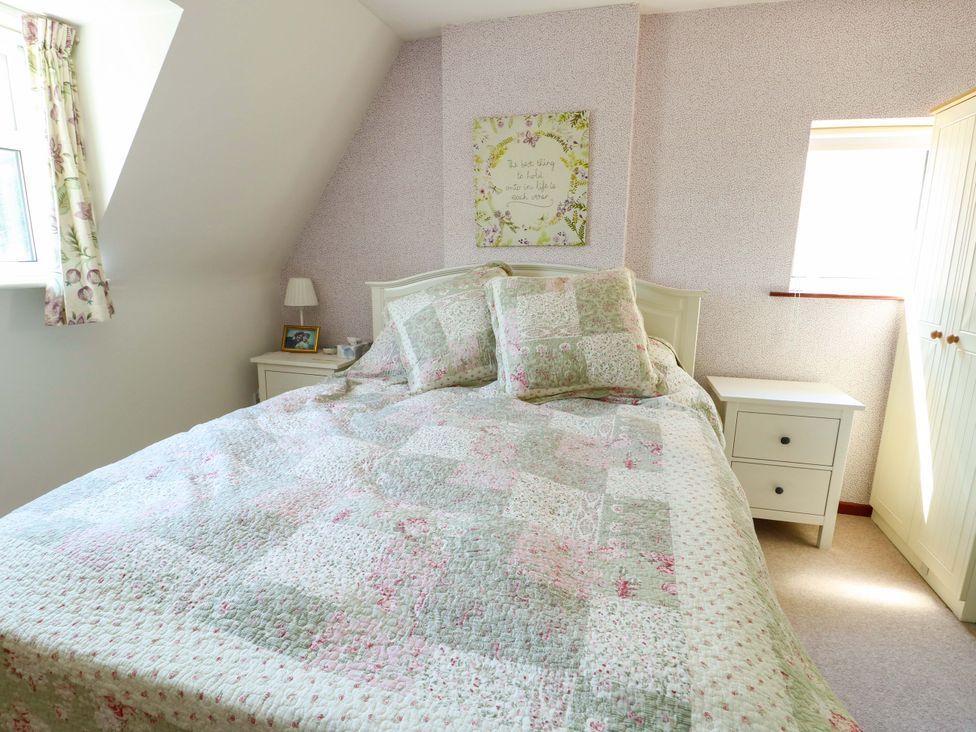 A bedroom with a bed and bedside table at Bryn Pydew in Llandudno Junction