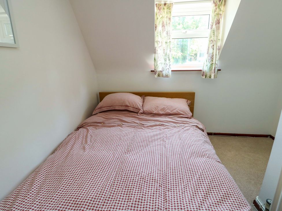 A bedroom with a bed and window at Bryn Pydew in Llandudno Junction