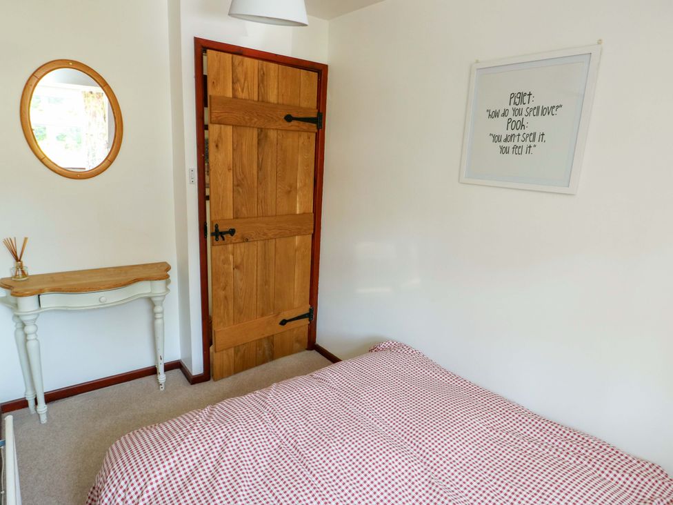 A bedroom with a bed and a wooden door at Bryn Pydew in Llandudno Junction