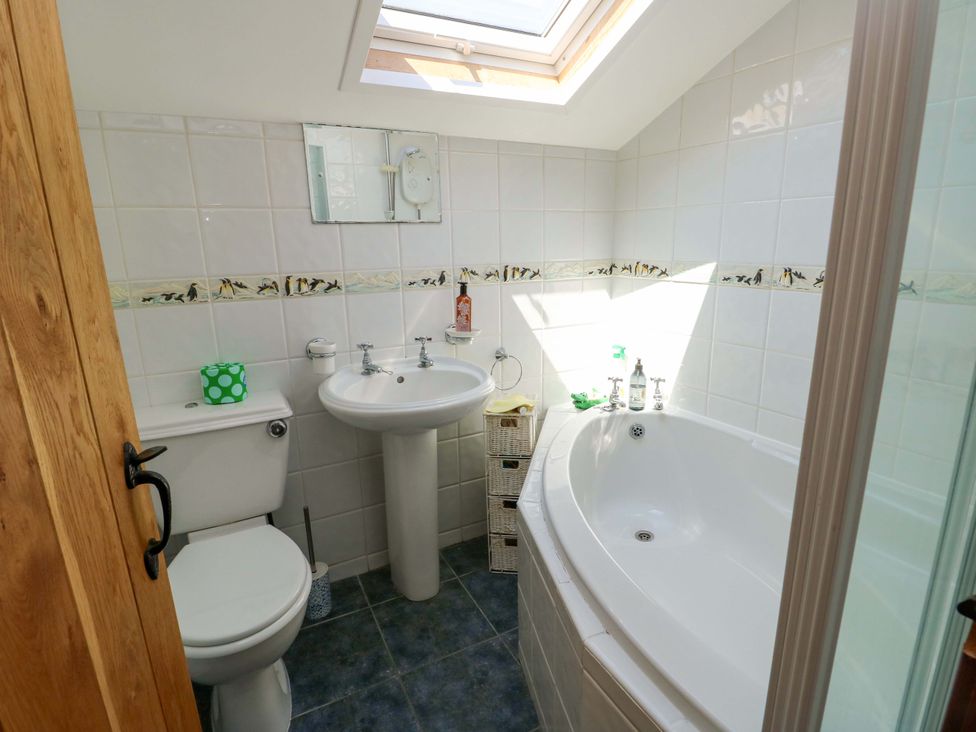 A bathroom with a bathtub and sink at Bryn Pydew in Llandudno Junction