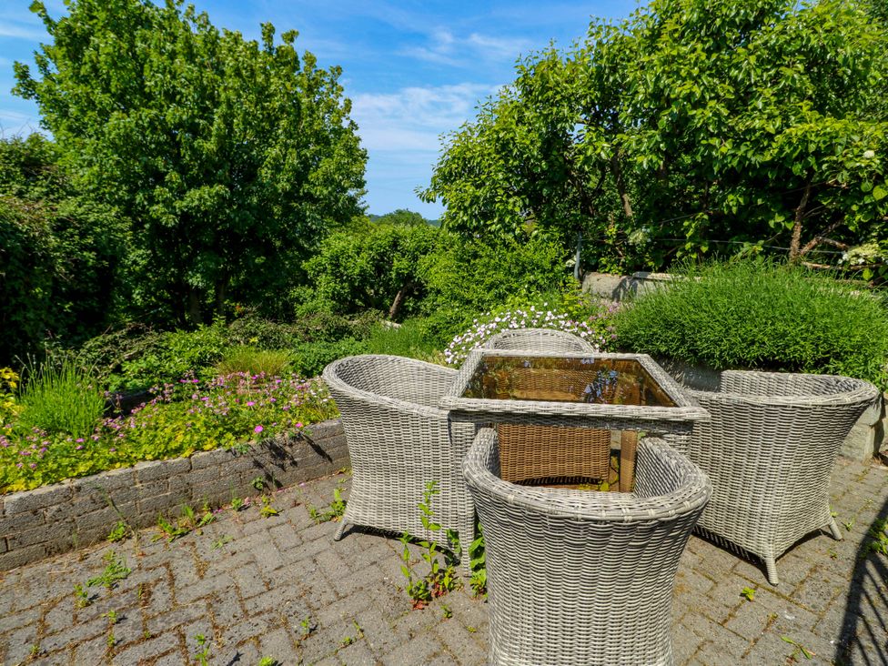 A garden with a table and chairs at Bryn Pydew in Llandudno Junction