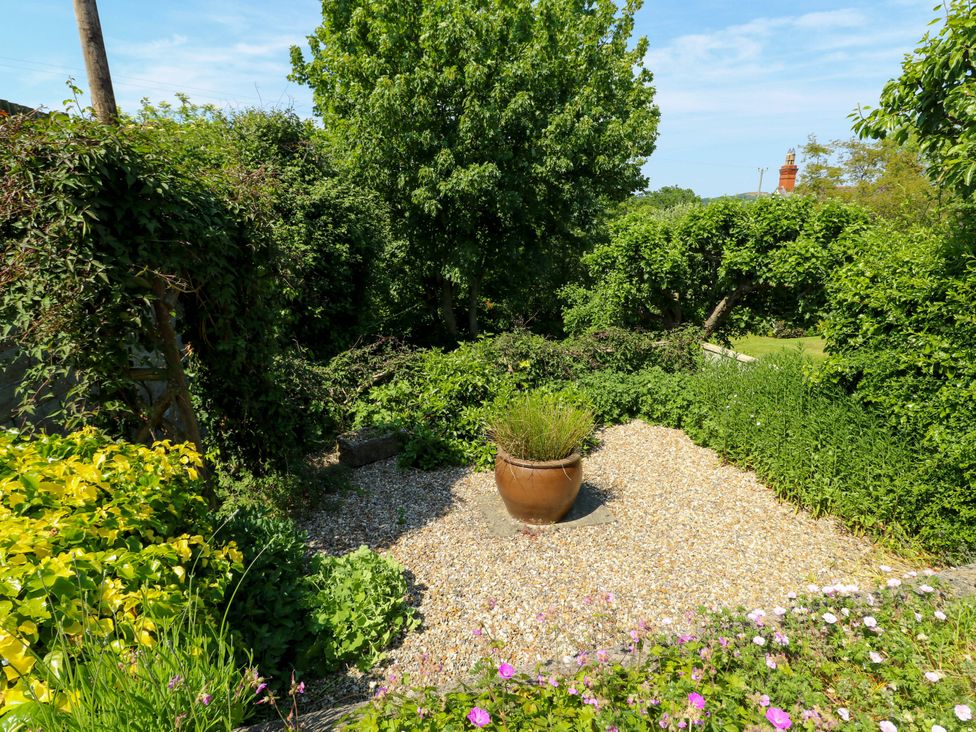 A garden with a gravel area and a planter at Bryn Pydew in Llandudno Junction