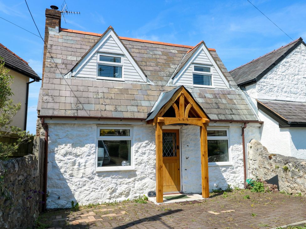 A house with a wooden door and windows at Bryn Pydew in Llandudno Junction