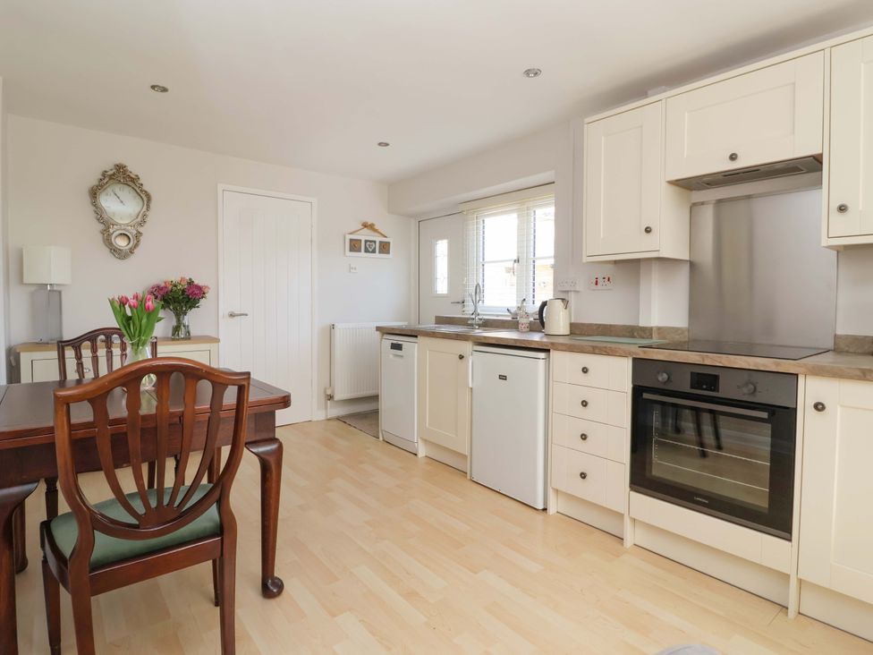 A kitchen with table and chairs at Cartwheel Cottage in Yearsley