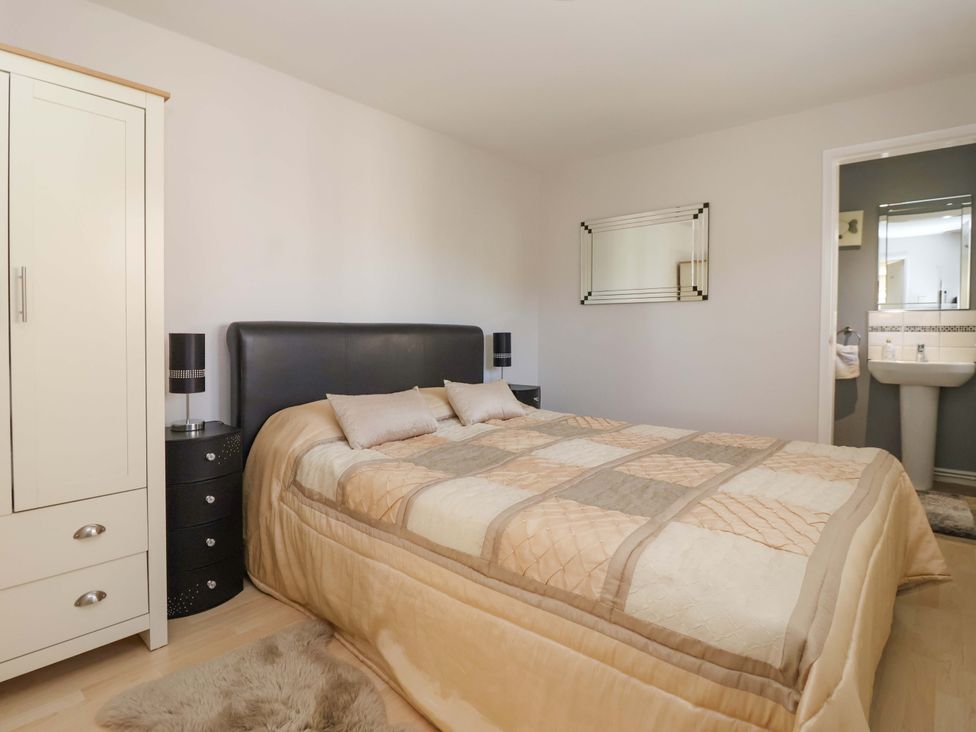 A bedroom with a bed and wardrobe at Cartwheel Cottage in Yearsley