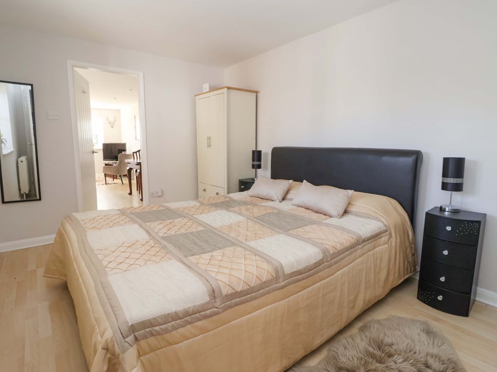 A bedroom with a bed and wardrobe at Cartwheel Cottage in Yearsley