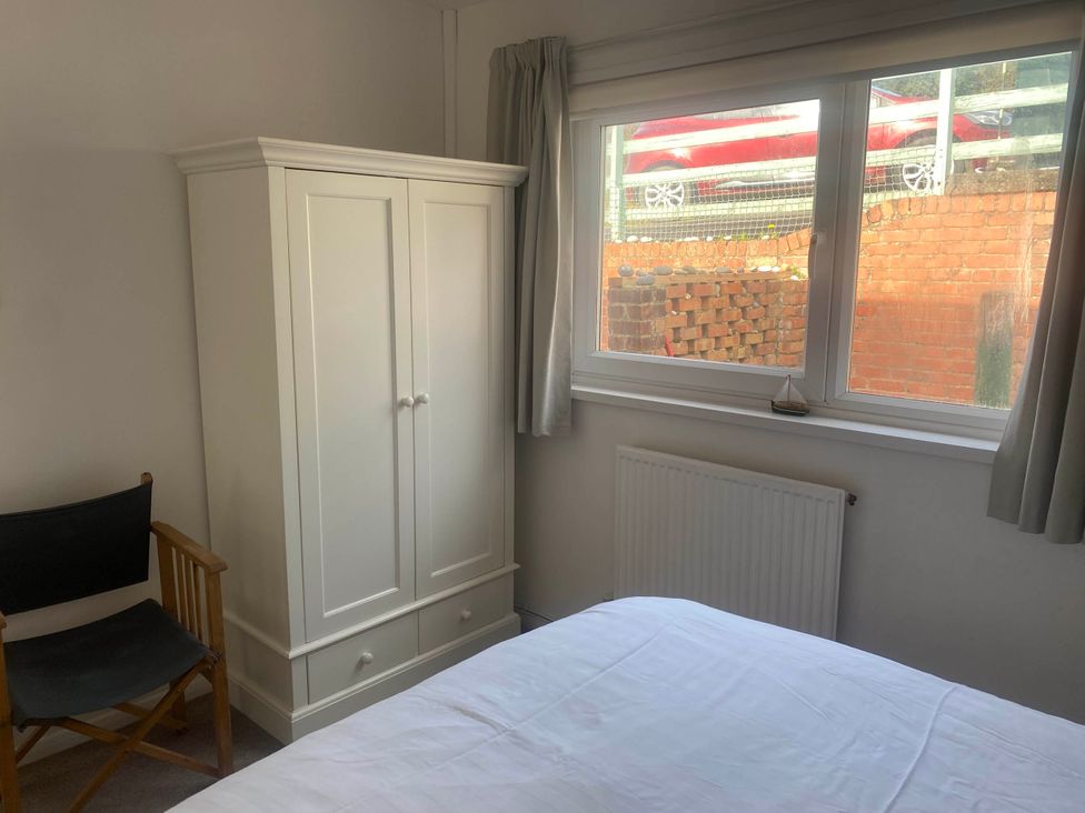 A bedroom with a bed and wardrobe at Valley High in Solva