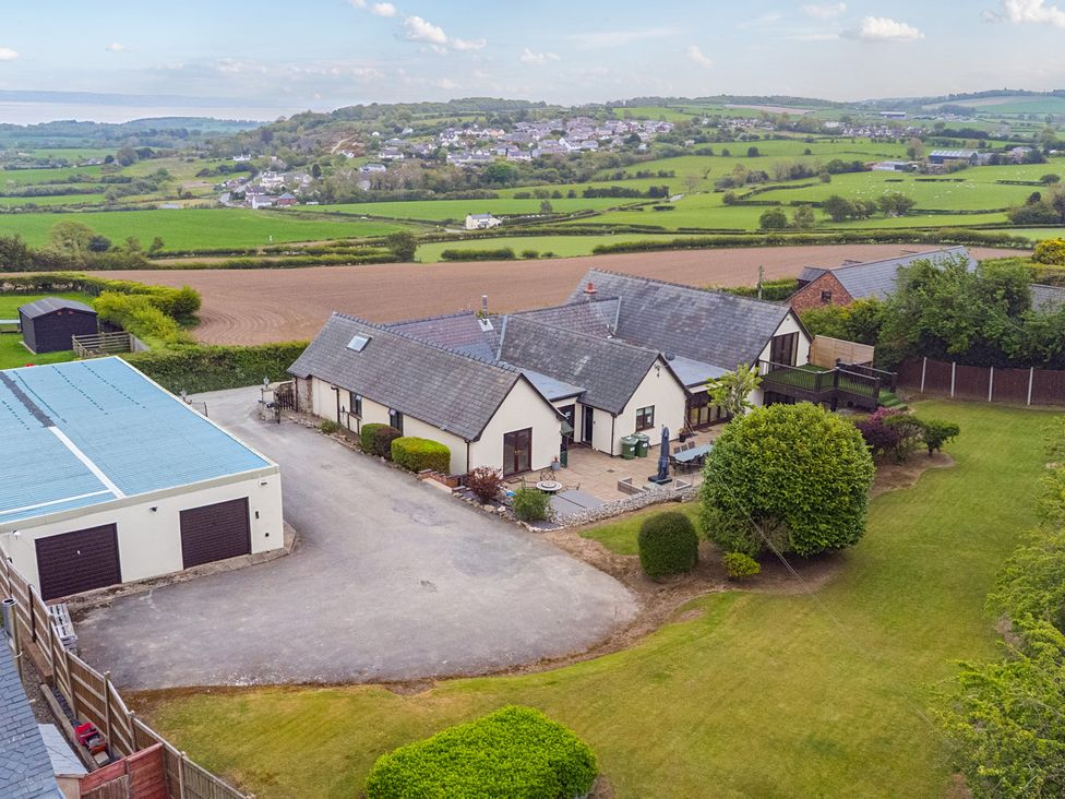 An aerial view of a house with garden and fields at Arosfa in Axton near Trelawynd