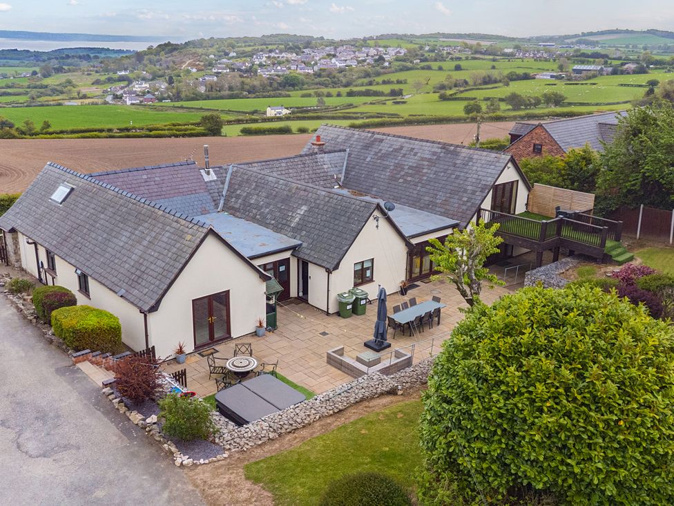 A house with a patio and garden area at Arosfa Axton near Trelawynd