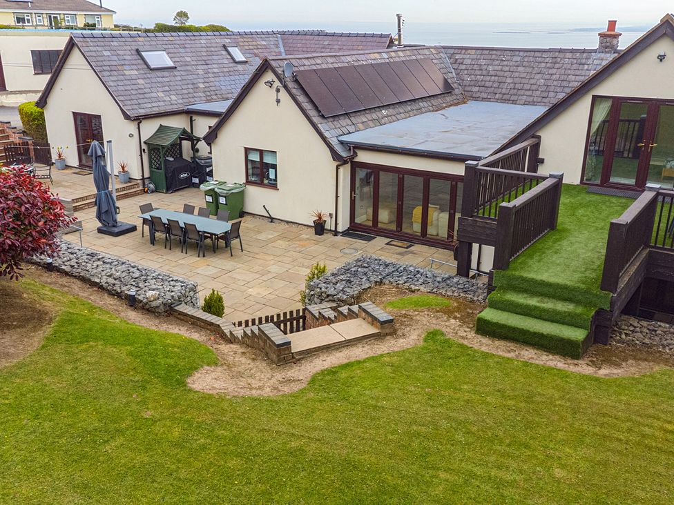 A patio with a table and chairs at Arosfa Axton near Trelawynd