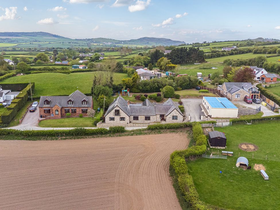 An aerial view of multiple houses and fields at Arosfa Axton near Trelawynd