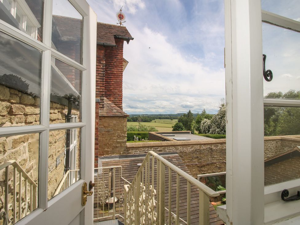 A balcony view with a stone wall and trees at The Old Nursery in Bourton near Much Wenlock