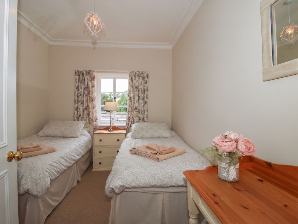 A bedroom with two beds and a window at The Old Nursery in Bourton near Much Wenlock