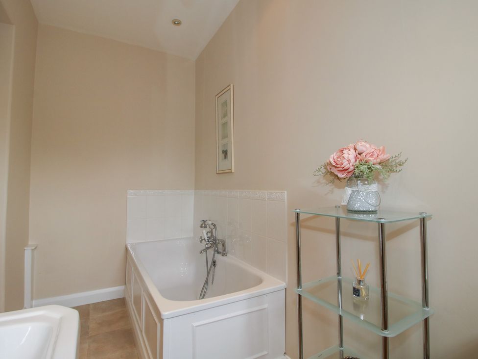A bathroom with a bath tub and shelf at The Old Nursery in Bourton near Much Wenlock