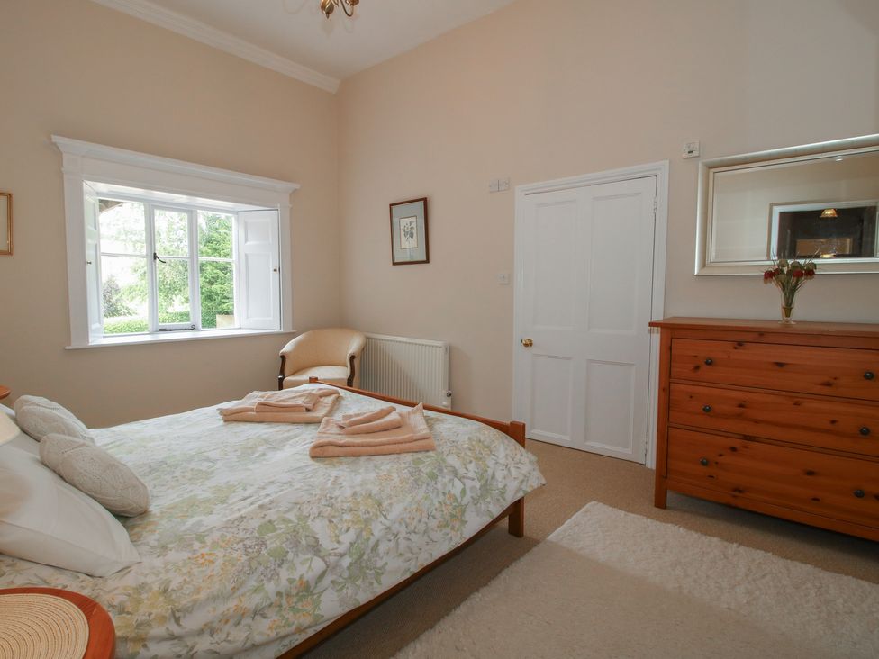 A bedroom with a bed and dresser at The Old Nursery in Bourton near Much Wenlock