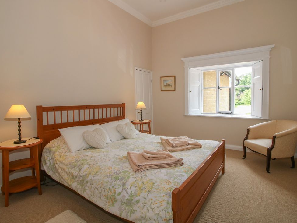 A bedroom with a bed and window at The Old Nursery in Bourton near Much Wenlock
