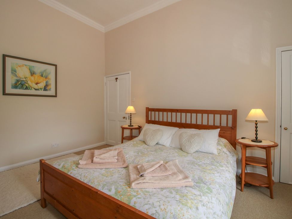 A bedroom with a bed and side tables at The Old Nursery in Bourton near Much Wenlock