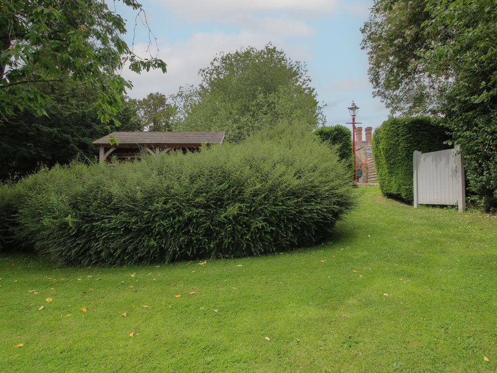 A garden area with a bush and a pathway at The Old Nursery in Bourton near Much Wenlock