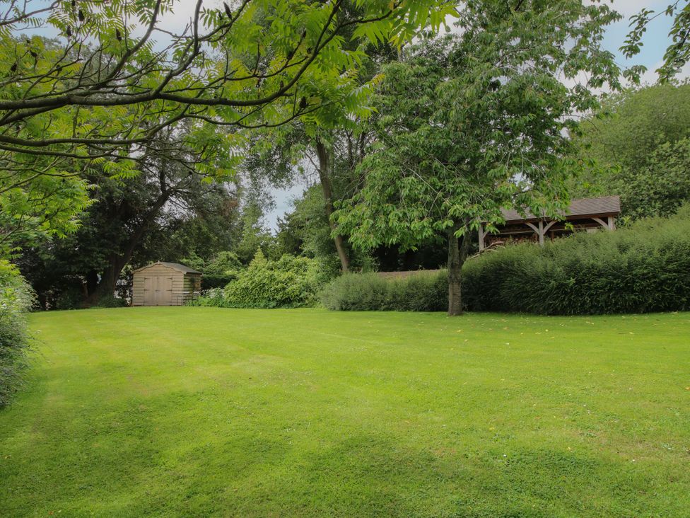 A garden with trees and a shed at The Old Nursery Bourton near Much Wenlock